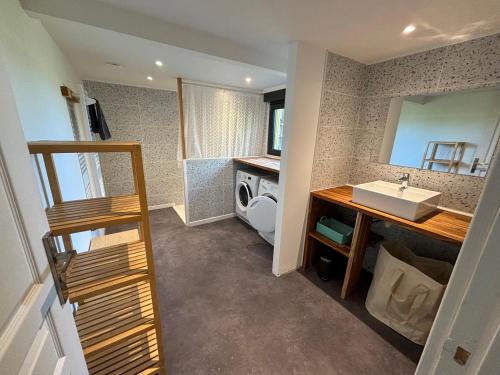 une salle de bain avec un lavabo et une machine à laver dans l'établissement la Bigoudène pour 8 personnes, à Les Hemmes de Marck