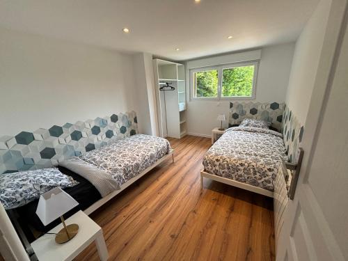 une chambre avec deux lits et une fenêtre dans l'établissement la Bigoudène pour 8 personnes, à Les Hemmes de Marck