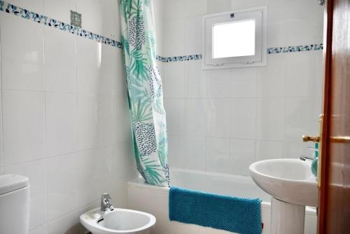 a bathroom with a sink and a toilet and a shower curtain at apartamento famara 4 in Famara