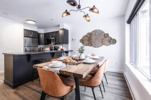 a dining room with a wooden table and chairs at L'Érablière Tremblant Ski Inout Condo W 2bdrs in Mont-Tremblant
