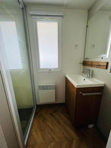 une salle de bain avec un lavabo et une fenêtre dans l'établissement Mobil'home Canet en Roussillon, à Canet