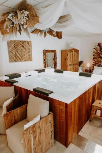a room with a large white counter with chairs at Suite de charme avec jacuzzi et cabine infrarouge in Tubize