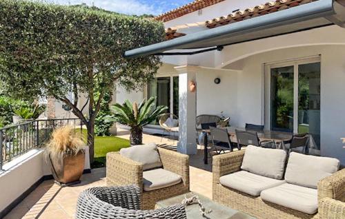 eine Terrasse mit Korbstühlen und einem Tisch in der Unterkunft Nice Home In La Londe Les Maures in La Londe-les-Maures