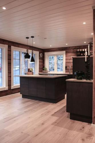 a large kitchen with wooden floors and a counter top at Tømmerhus i Geiranger Sentrum med panorama utsikt in Geiranger