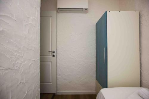 a bedroom with a blue cabinet and a white wall at Villa Costarei minipiscina in Costa Rei