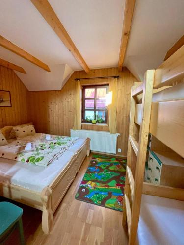 a bedroom with two bunk beds and a rug at Chalupa Beliankovo Ždiar in Ždiar