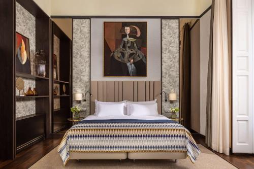 a bedroom with a king sized bed and a painting at NH Collection Madrid Palacio de Tepa in Madrid