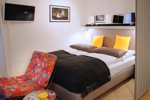 1 dormitorio con 1 cama y 1 silla en Rheintor-Apartment en Espira