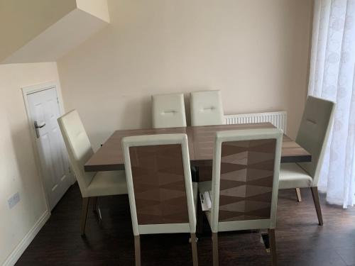 a dining room with a wooden table and chairs at Holytown Homes in Holytown