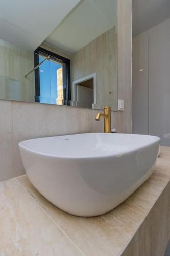 a large white sink in a bathroom with a mirror at Ocean View 1111 Retreat in Rikia