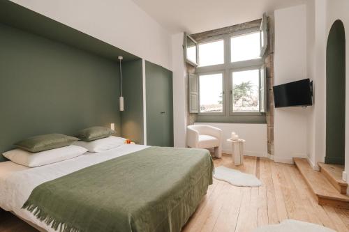 a bedroom with a large bed with a green wall at La Demeure de la Cité by Jean Bacou in Carcassonne