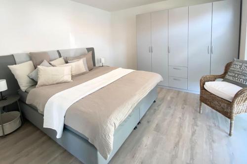 a bedroom with a large bed and a chair at Oh my Deer nagelneues Appartement für Zwei in Tauberbischofsheim
