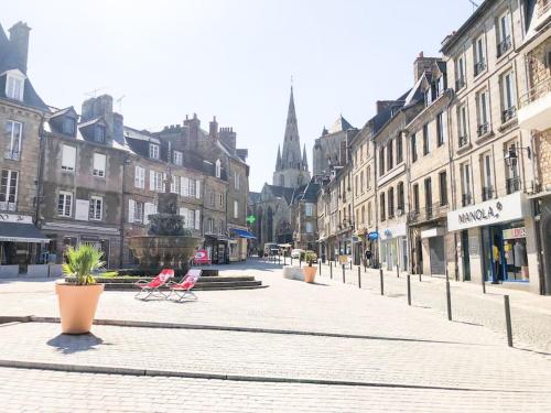 an empty city street with two chairs and buildings at NEW Élégance et Confort face à la gare Parking in Guingamp