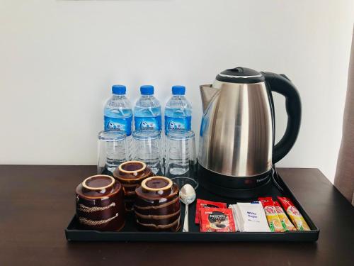a tray with cups and bottles of water on a table at R21 Nuwara Eliya in Nuwara Eliya