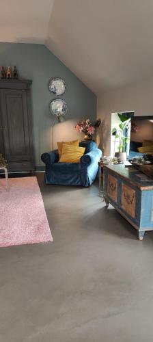 a living room with a bed and a table at Vakantiehuisje Bellefleur huisje Daisy in Roderwolde