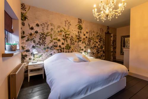 a bedroom with a bed and a chandelier at Vakantiehuisje Bellefleur huisje Daisy in Roderwolde