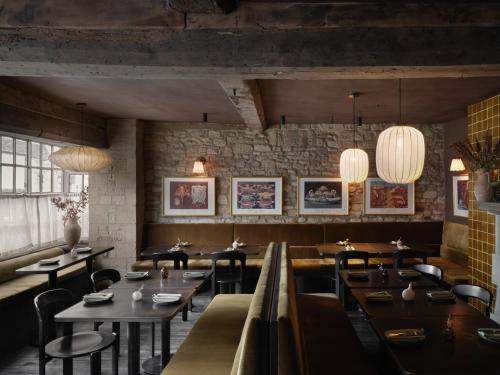 a restaurant with wooden tables and chairs and lights at Highway in Burford