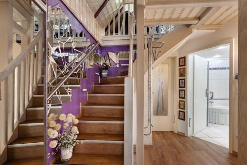 a staircase in a house with purple walls and wooden floors at Ferienhaus In Oerrel Mit Pool in Faßberg