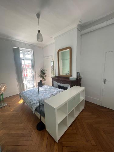 une chambre blanche avec un lit et un miroir dans l'établissement Chambre Comtesse - Climatisée - Proximité métro, à Toulouse