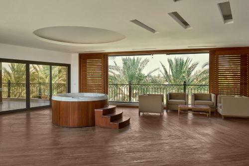 a lobby with a table and chairs and a balcony at Hilton Alexandria King's Ranch Hotel in Alexandria