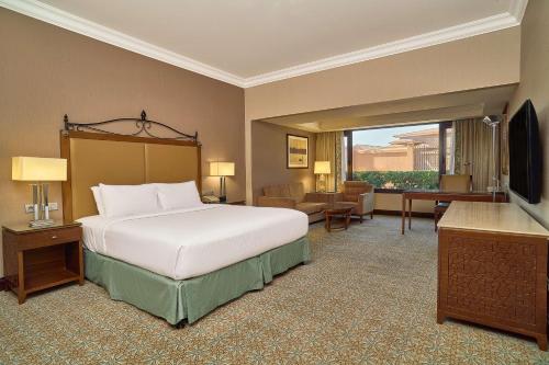 a hotel room with a bed and a television at Hilton Alexandria King's Ranch Hotel in Alexandria