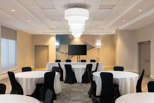 a conference room with tables and chairs and a tv at Hilton Garden Inn Daytona Beach Oceanfront in Daytona Beach