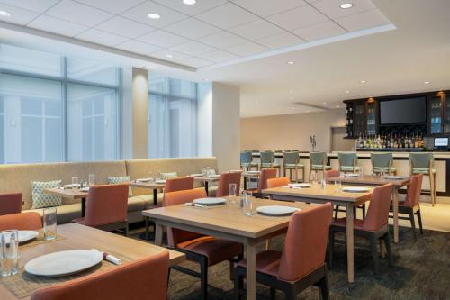 a restaurant with tables and chairs and a bar at Hilton Garden Inn Daytona Beach Oceanfront in Daytona Beach