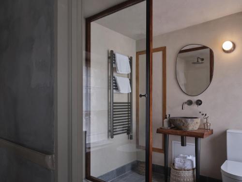 a bathroom with a shower and a sink and a mirror at Highway in Burford