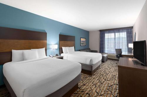 a hotel room with two beds and a flat screen tv at La Quinta by Wyndham Cullman in Cullman