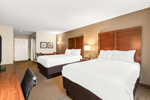 a hotel room with two beds and a flat screen tv at Comfort Inn & Suites North Conway in North Conway
