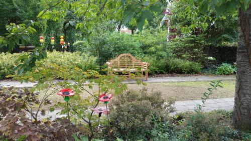 a bench sitting in the middle of a garden at Hotel Lemmenhof in Ell