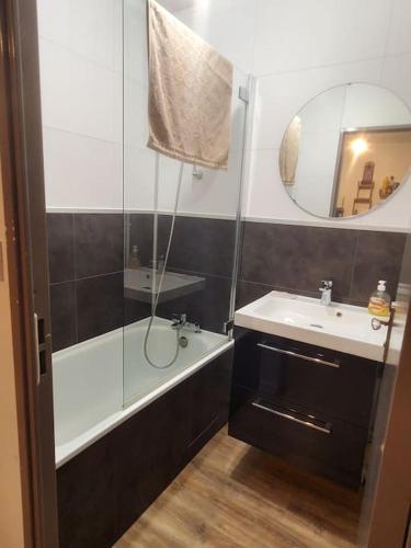 une salle de bain avec une douche, un lavabo et un miroir dans l'établissement Appartement T2 très cosy proche centre ville, à Sorges