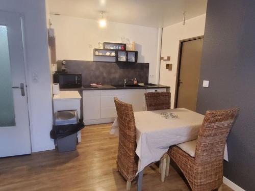 une cuisine avec une table et des chaises dans une pièce dans l'établissement Appartement T2 très cosy proche centre ville, à Sorges