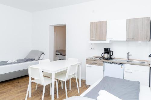 a white kitchen with a table and chairs and a bed at Z.Bilić V&V in Jesteburg