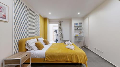 une chambre avec un lit avec une couverture jaune dans l'établissement Bluestay 6 - Superbe appartement à Paris, à Paris