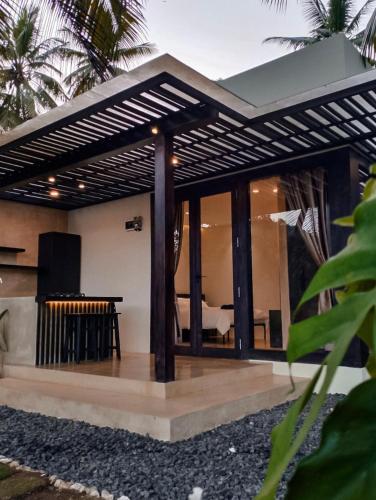 a house with a patio with a dining area at lojiwangi batukaras in Batukaras