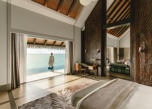 a bedroom with a bed and a view of the ocean at JOALI Maldives in Raa Atoll