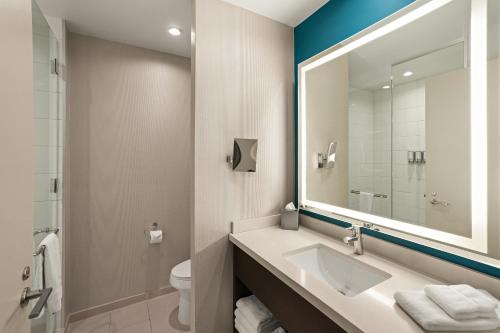 a bathroom with a sink and a mirror and a toilet at Sonesta Bee Cave Austin Hill Country in Bee Cave