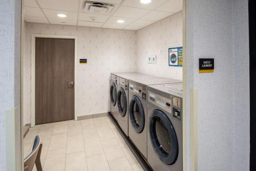 a laundry room with three washing machines in it at Home2 Suites By Hilton East Haven New Haven in East Haven