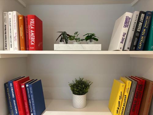 a book shelf with books and a potted plant at The Cadogan Suite by Harrods in London