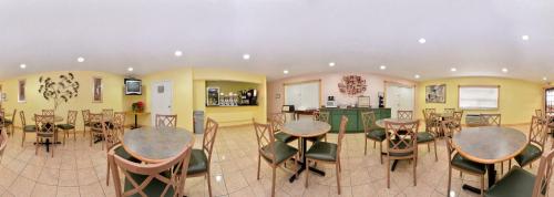 a room with tables and chairs and a kitchen at Five Star Inn Burleson in Burleson
