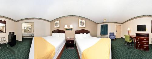 a hotel room with two beds and a television at Five Star Inn Burleson in Burleson