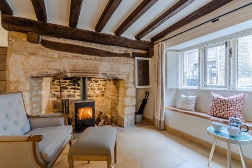 a living room with a fireplace and a couch at Spinner's Cottage in Burford