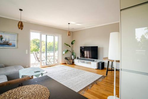 a living room with a couch and a tv at Luxuriöse Wohnung mit Terrasse, Balkon und Wasserbett - 24h Check-In in Garbsen