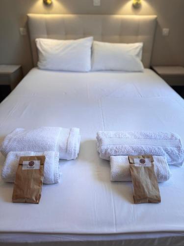 a white bed with two towels and two wooden blocks on it at Fenareti Apartments in Skala Eresou