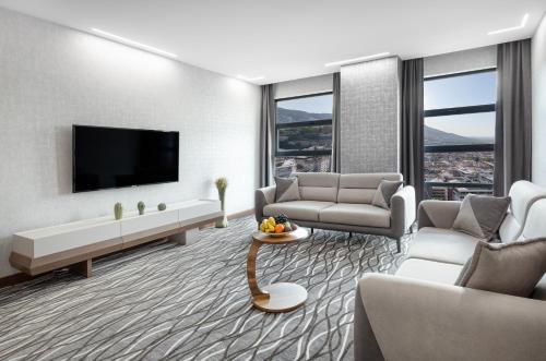 a living room with a couch and a tv at Lilium Hotel & Suites in Bursa
