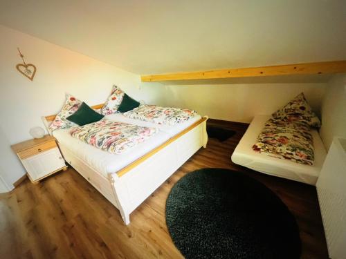 a small bedroom with two beds and a rug at Ferienwohnung Lory mit Schlossblick in Halblech