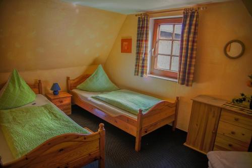 a bedroom with two twin beds and a window at Hof Brockmann - Ferienhaus Spieker in Neuenkirchen