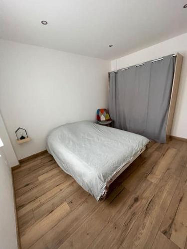 une chambre avec un lit et un parquet dans l'établissement Séjour en montagne, à La Cabanasse