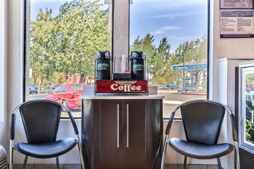 a coffee table with two chairs in front of a window at Motel 6-Pleasanton, CA in Pleasanton